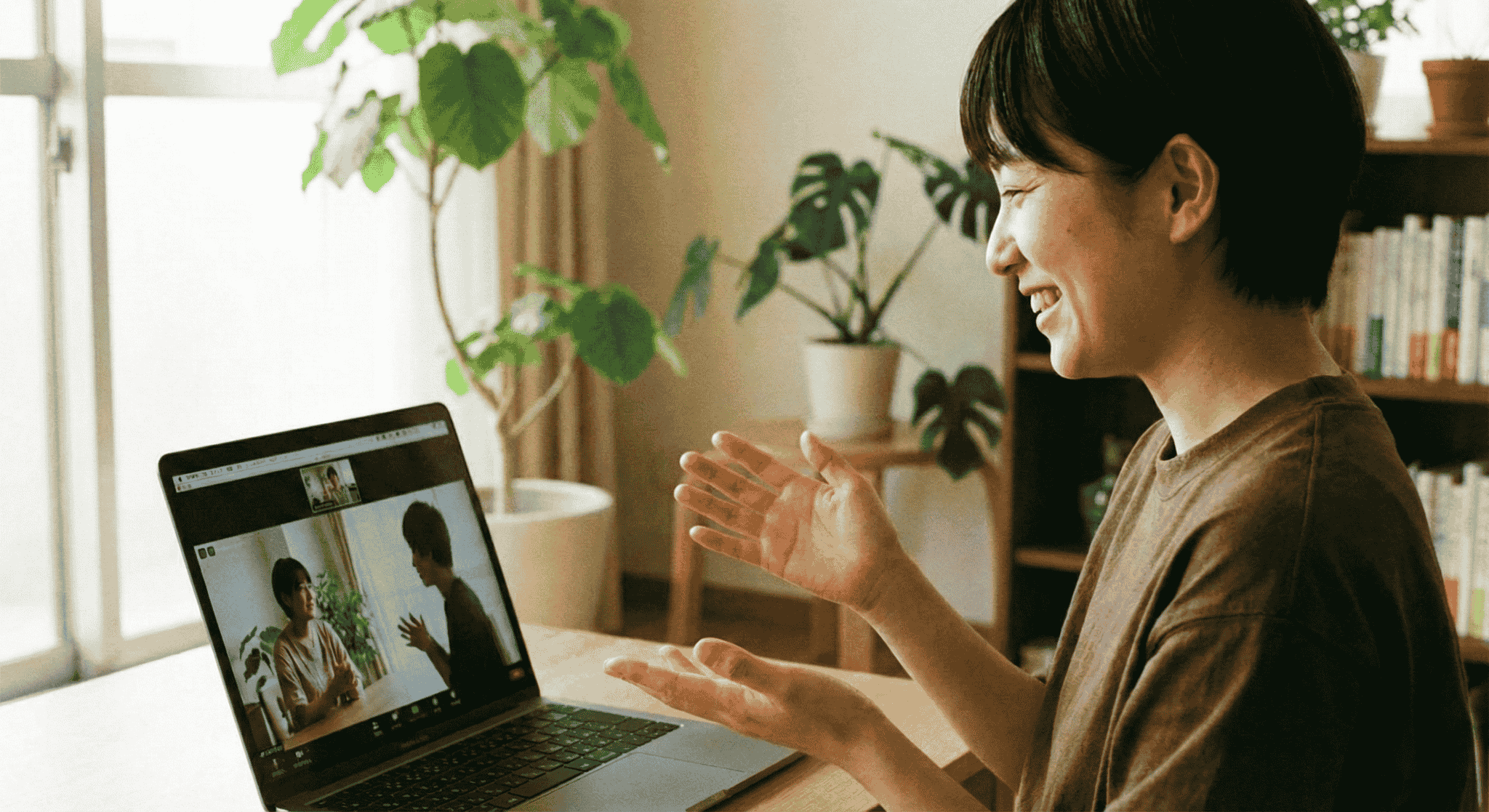 ノートPCでオンライン通話をする女性